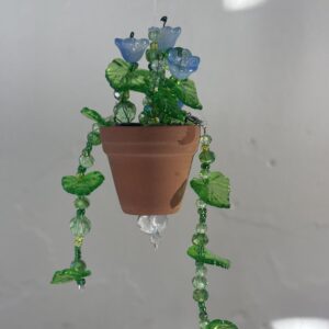 Blue flowers with green vines in plain terra cotta 2" pot