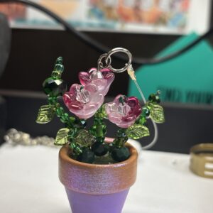 Dark pink flowers, green leaves in purple 1" pot